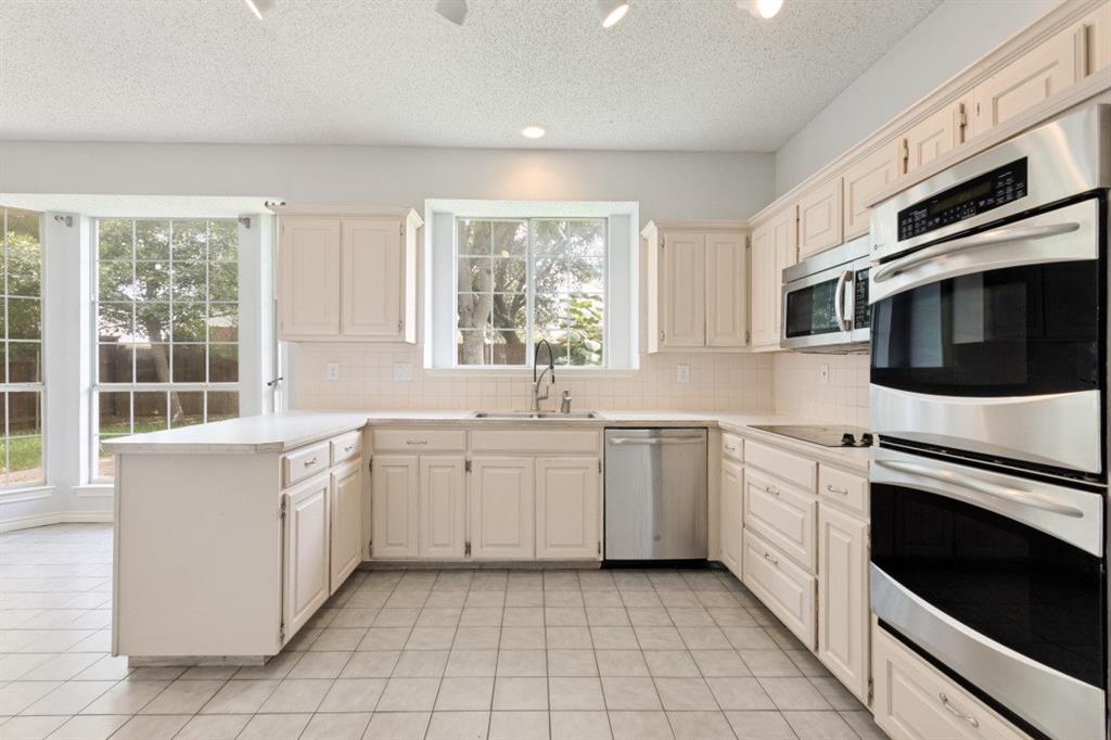 4709 Portrait Lane Plano, TX 75024 - Photo 7 of 22 Kitchen features double ovens, plentiful cabinetry, and convenient meal-prep areas.