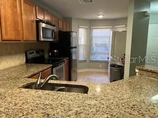 a kitchen with granite countertop a sink and a stove top oven