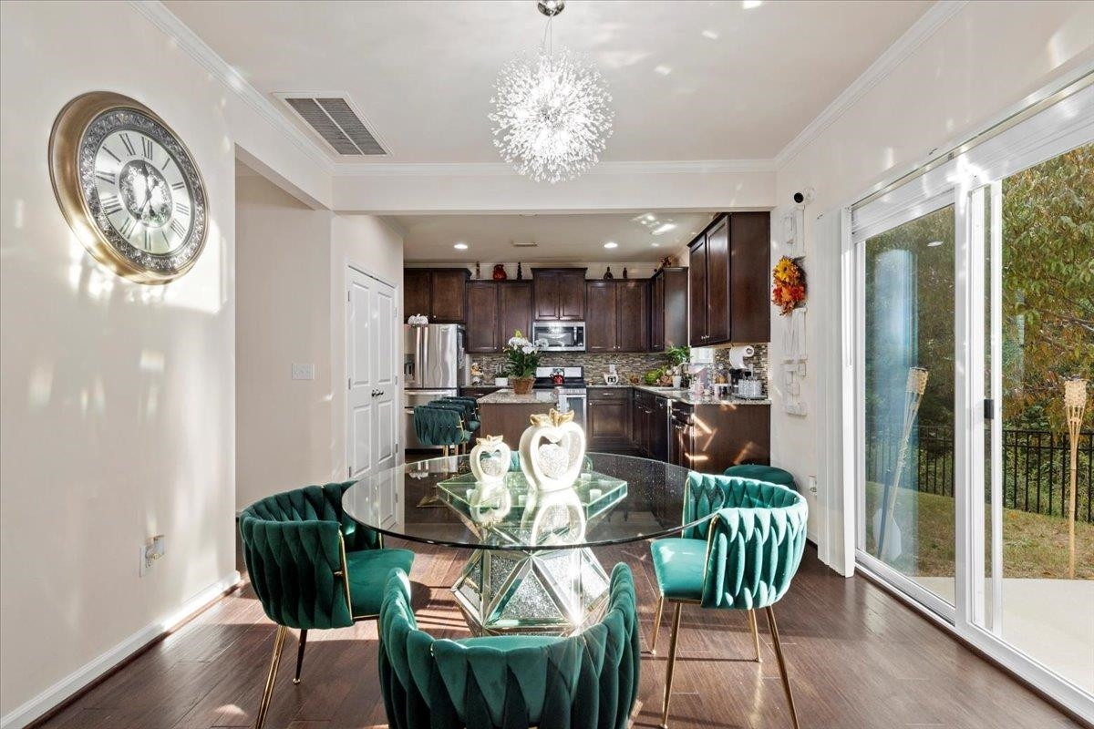 3537 Massey Ridge Court Raleigh, NC 27616 - Photo 15 of 41 a view of a dining room with furniture a chandelier and wooden floor