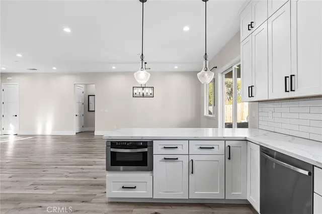 a kitchen with stainless steel appliances granite countertop a sink a stove and a refrigerator
