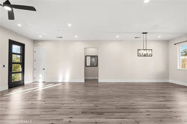 a view of an empty room with window and wooden floor