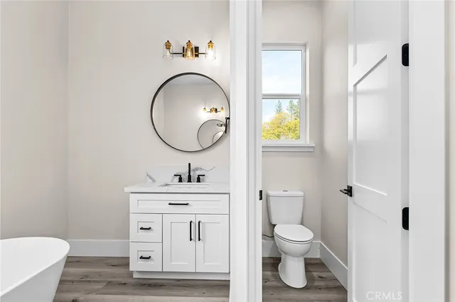 a bathroom with a toilet a sink and mirror