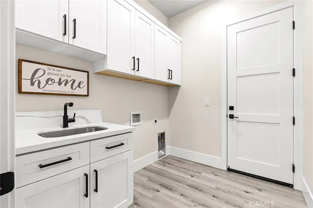 a view of a sink storage and utility room with closet