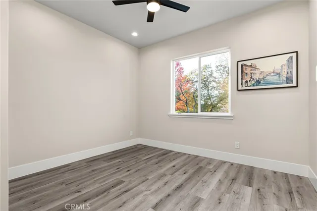 an empty room with a window and wooden floor