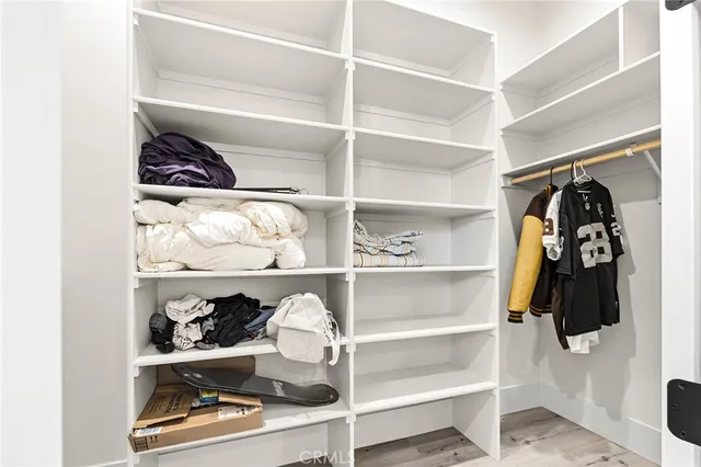 a view of walk in closet with clothes and shoes