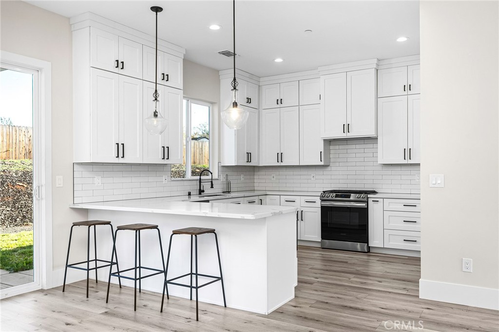 96 Valley View Drive Paradise, CA 95969 - Photo 4 of 47 a kitchen with stainless steel appliances granite countertop a stove a sink a refrigerator and white cabinets