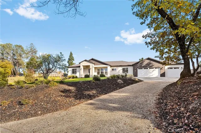 a front view of a house with a yard and large trees