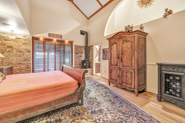 a bedroom with a bed a mirror and next to a window