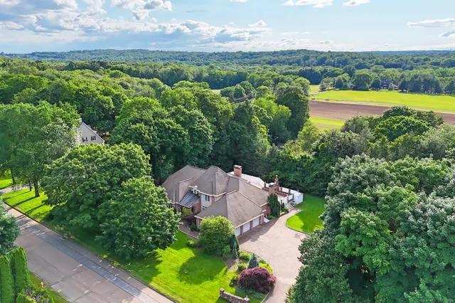 an aerial view of a house with a garden and lake view