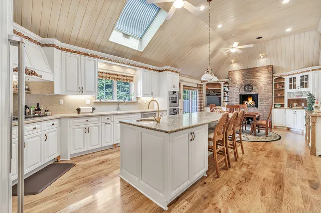 a kitchen with stainless steel appliances kitchen island granite countertop a sink and cabinets