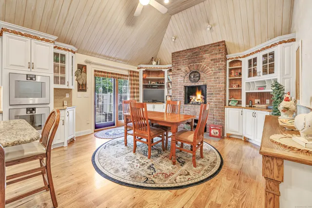 a dining room with furniture a floor to ceiling window and wooden floor