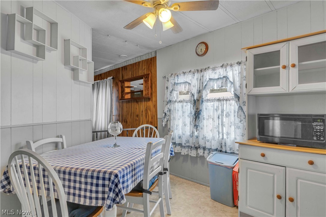6610 Lear Nagle Road, Unit 154 North Ridgeville, OH 44039 - Photo 13 of 26 Dining area with wooden walls, ceiling fan, and light floors