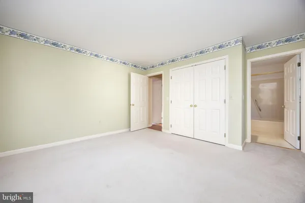 a view of an empty room with a chandelier fan