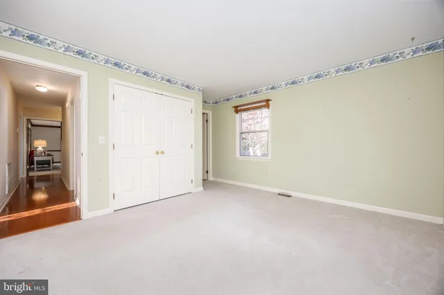 a view of a hallway with wooden floor and closet