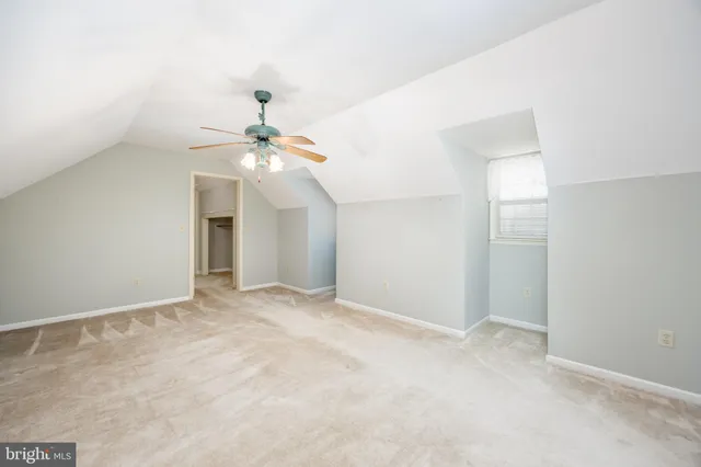 a view of a white house next to a yard with plants and trees