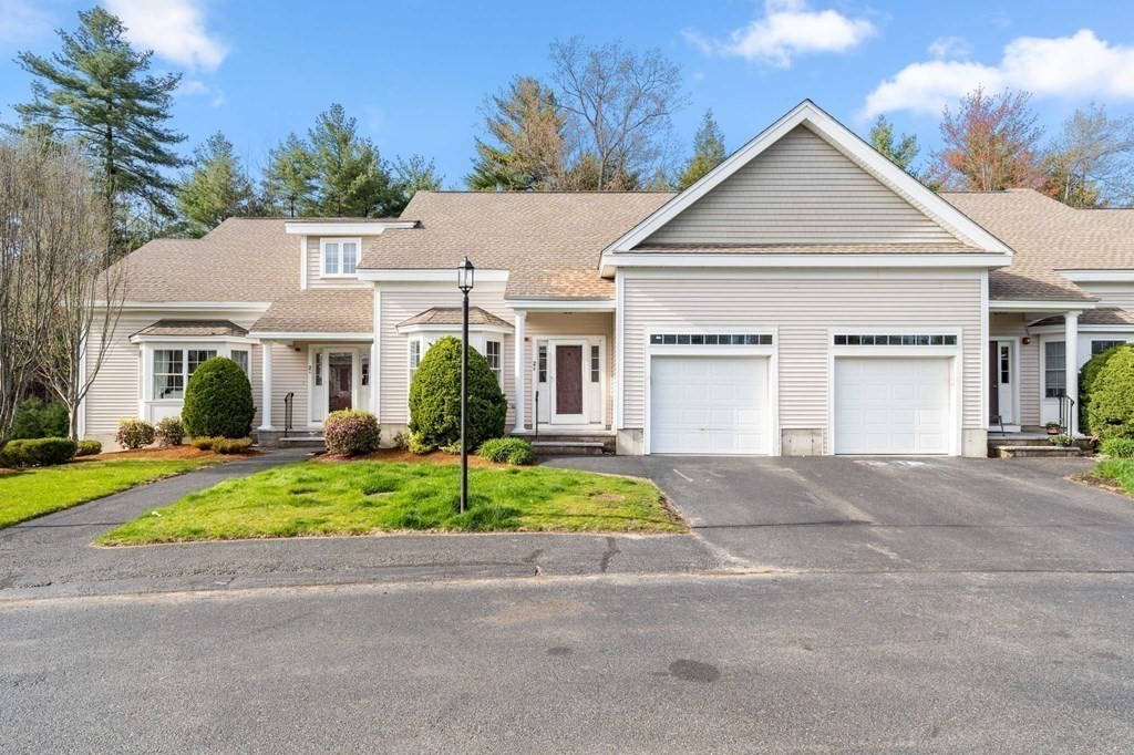 a front view of a house with a yard and a garage