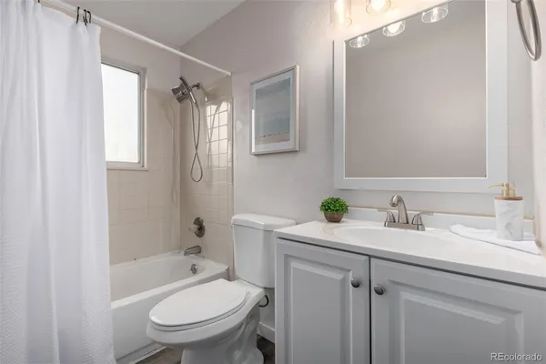 a bathroom with a granite countertop toilet sink and a mirror