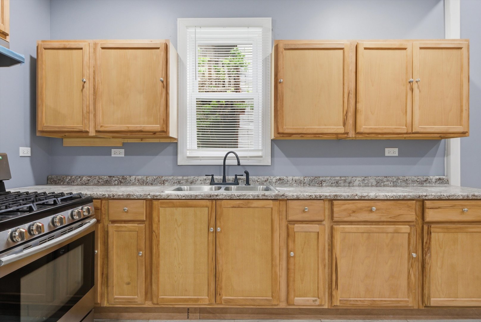 7828 South Escanaba Avenue Chicago, IL 60649 - Photo 16 of 41 a kitchen with granite countertop cabinets and window