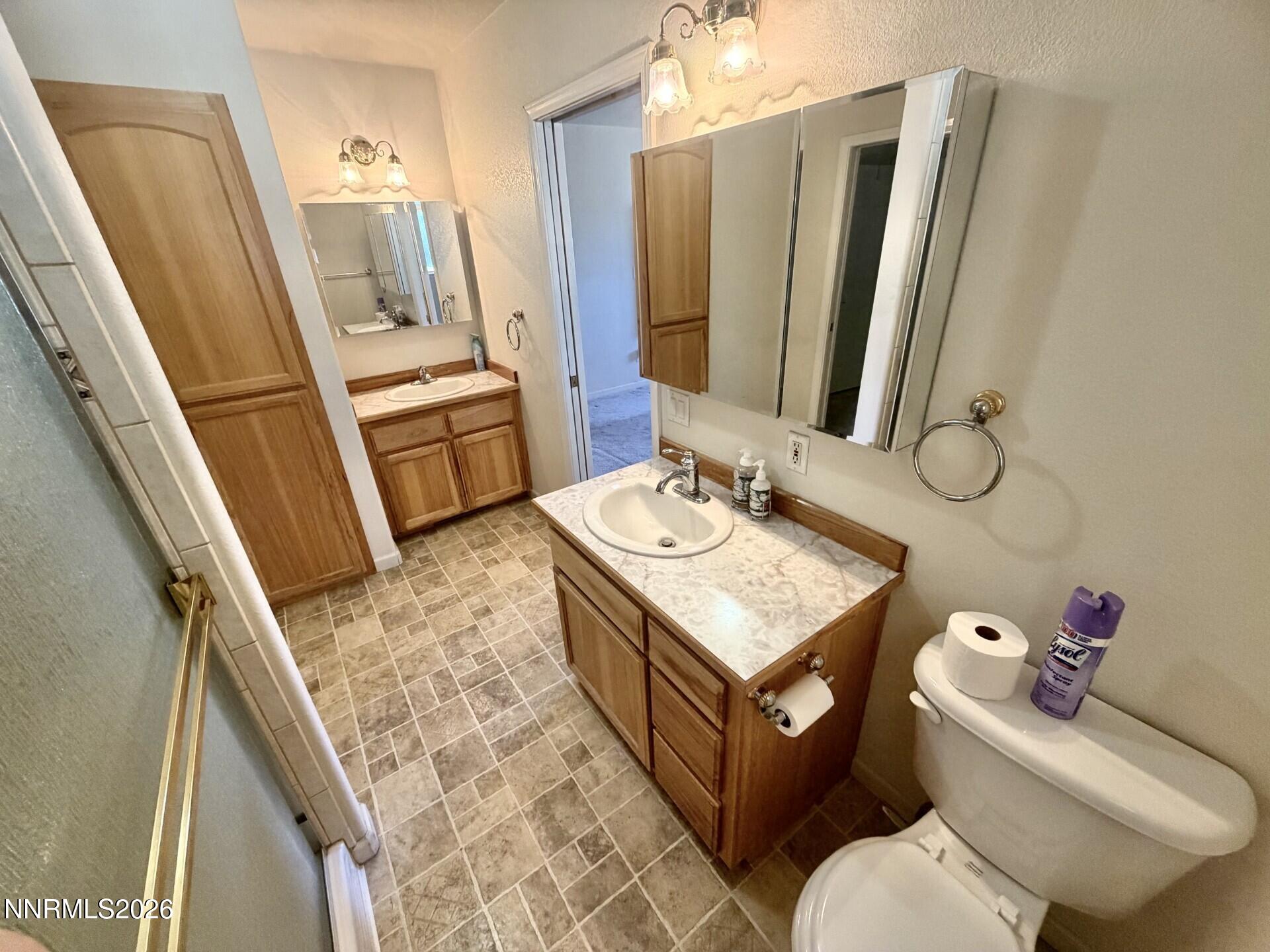 765 Hunter Park Way Fallon, NV 89406 - Photo 11 of 30 a bathroom with a granite countertop sink mirror vanity and toilet