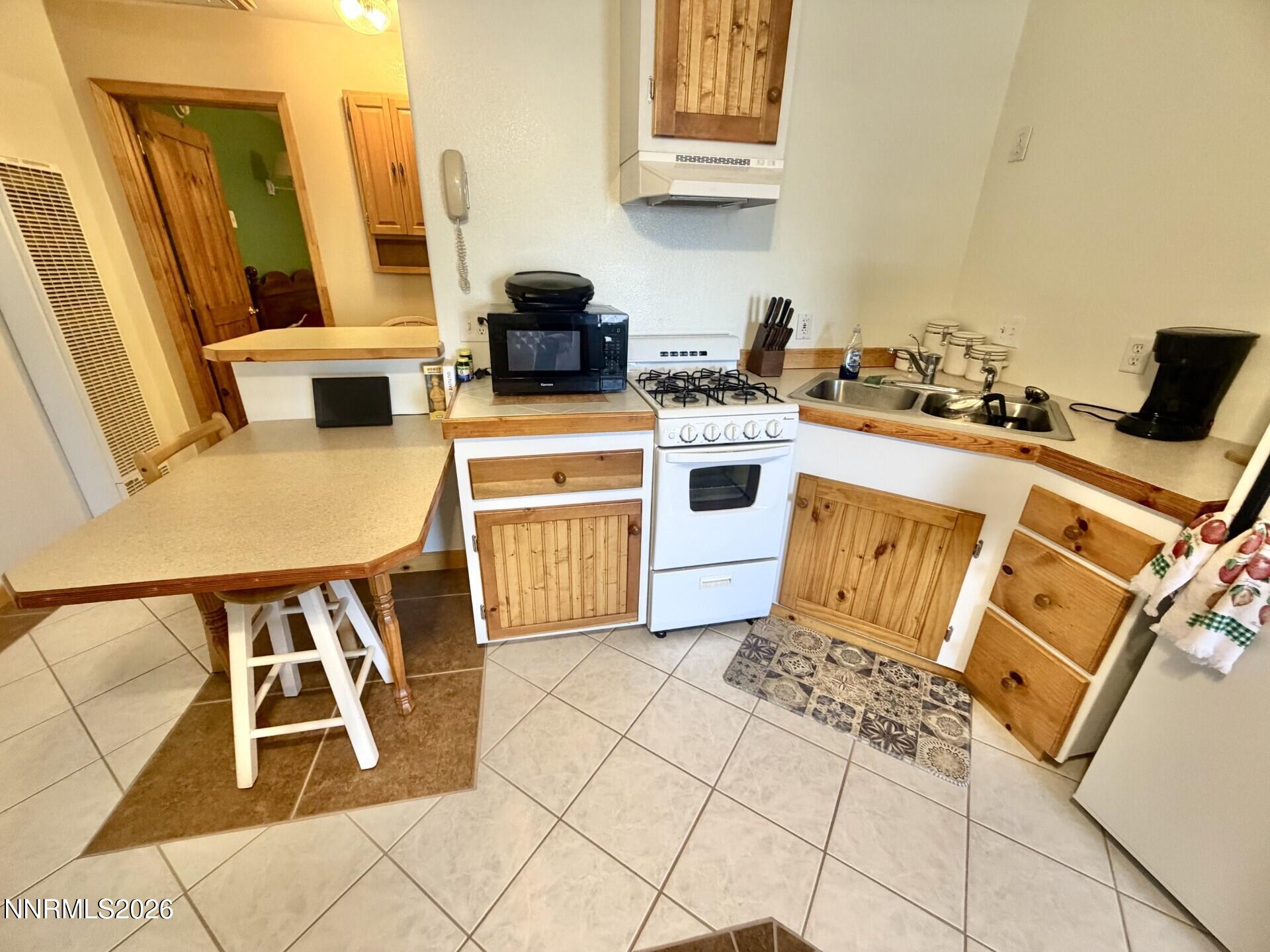 765 Hunter Park Way Fallon, NV 89406 - Photo 21 of 30 a kitchen with a stove and a white refrigerator