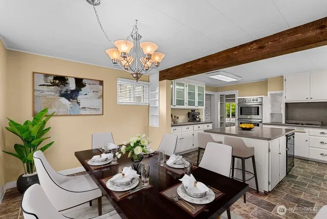 a view of a dining room with furniture a livingroom and chandelier