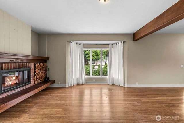 a view of an empty room with window and fire place