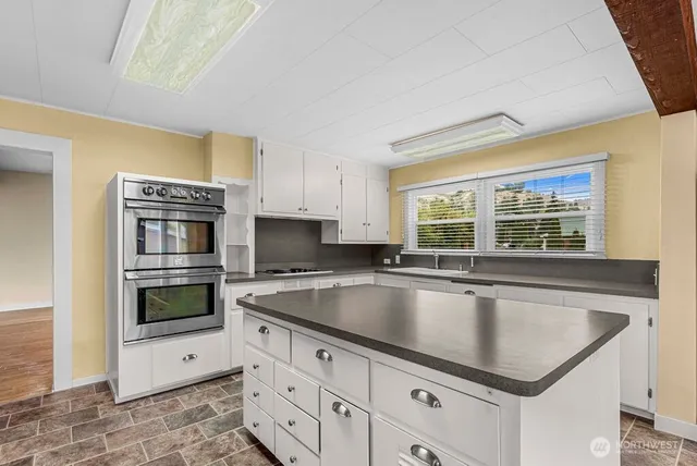 a kitchen with granite countertop a sink and stove top oven