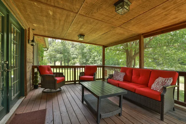 a balcony with wooden floor red walls and a table