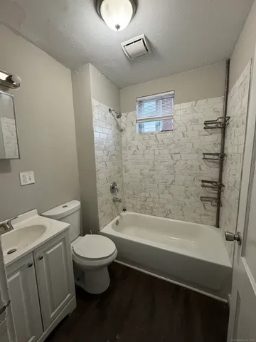 a bathroom with a granite countertop toilet a sink and bathtub