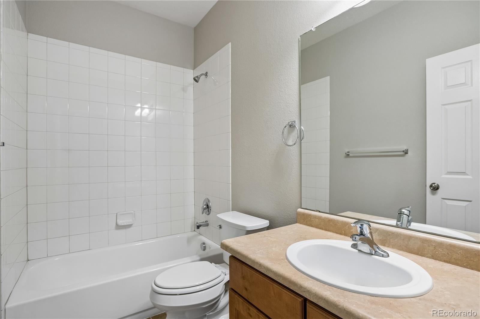 5031 South Rome Street Aurora, CO 80015 - Photo 22 of 39 a bathroom with a sink a toilet and a mirror
