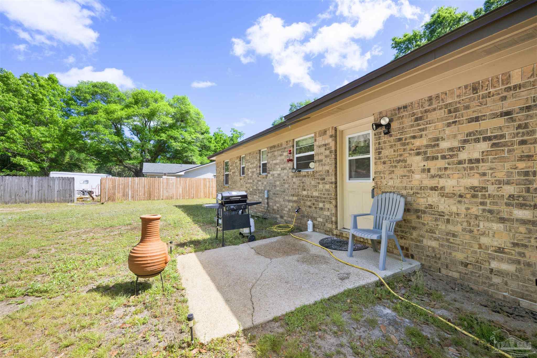 5131 Oakleaf Drive Pace, FL 32571 - Photo 15 of 23 a view of a backyard with table and chairs and potted plants