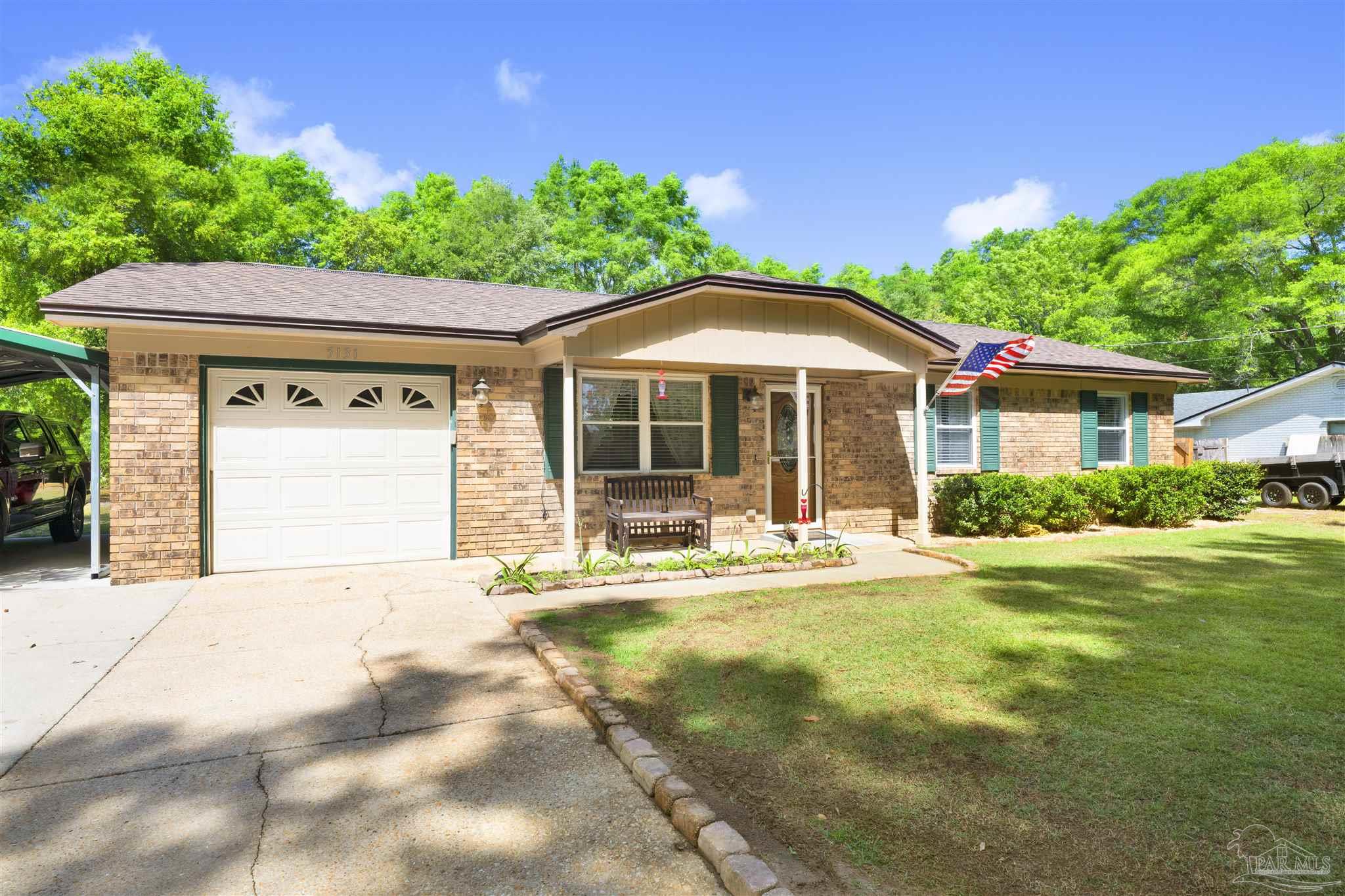 5131 Oakleaf Drive Pace, FL 32571 - Photo 20 of 23 a front view of a house with a yard and garage