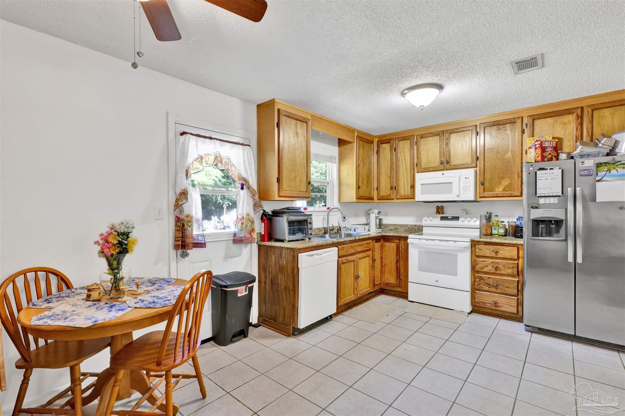 5131 Oakleaf Drive Pace, FL 32571 - Photo 6 of 23 a kitchen with stainless steel appliances granite countertop a stove a sink dishwasher and a refrigerator
