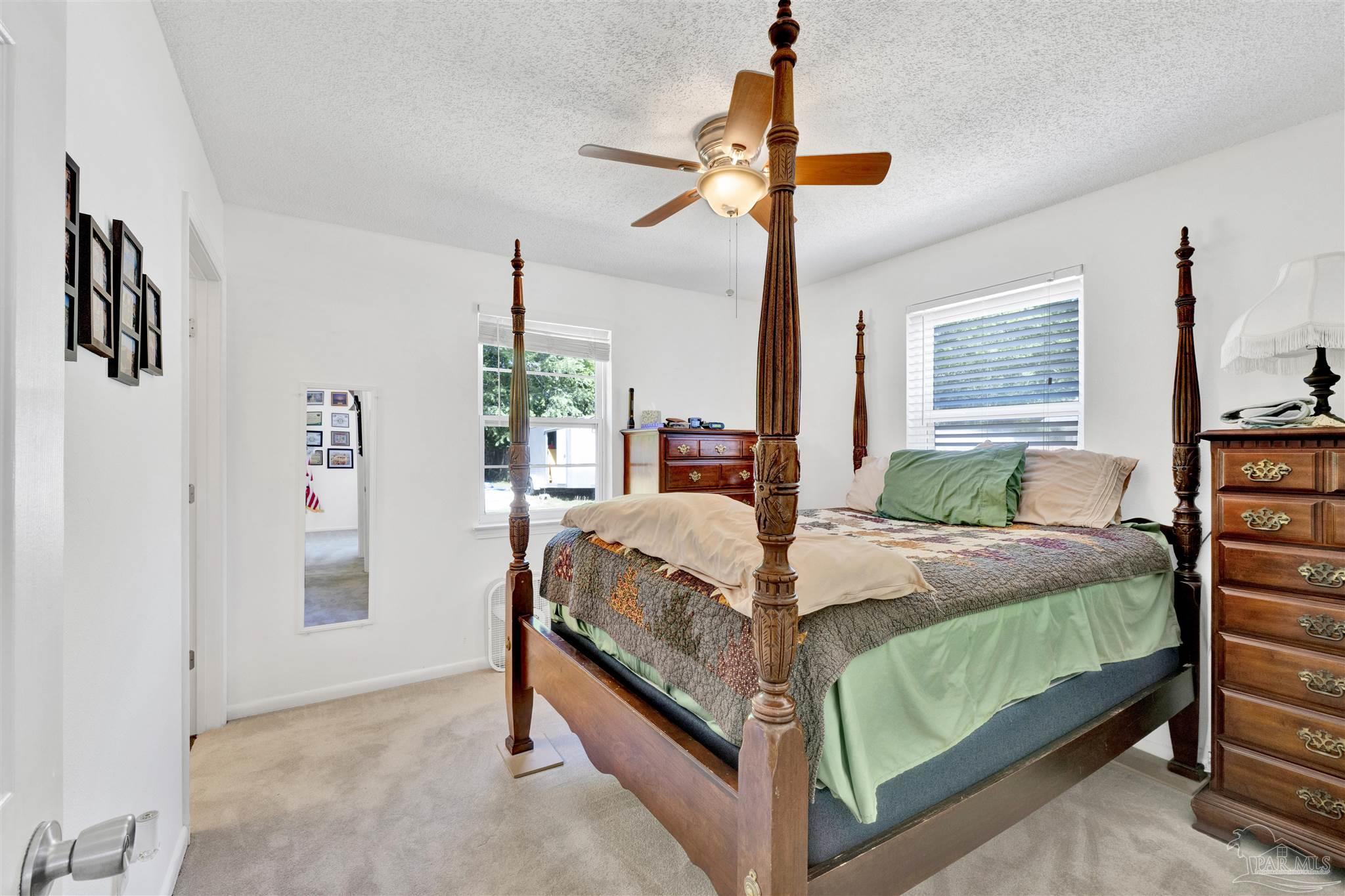 5131 Oakleaf Drive Pace, FL 32571 - Photo 8 of 23 a bedroom with a bed and a chandelier