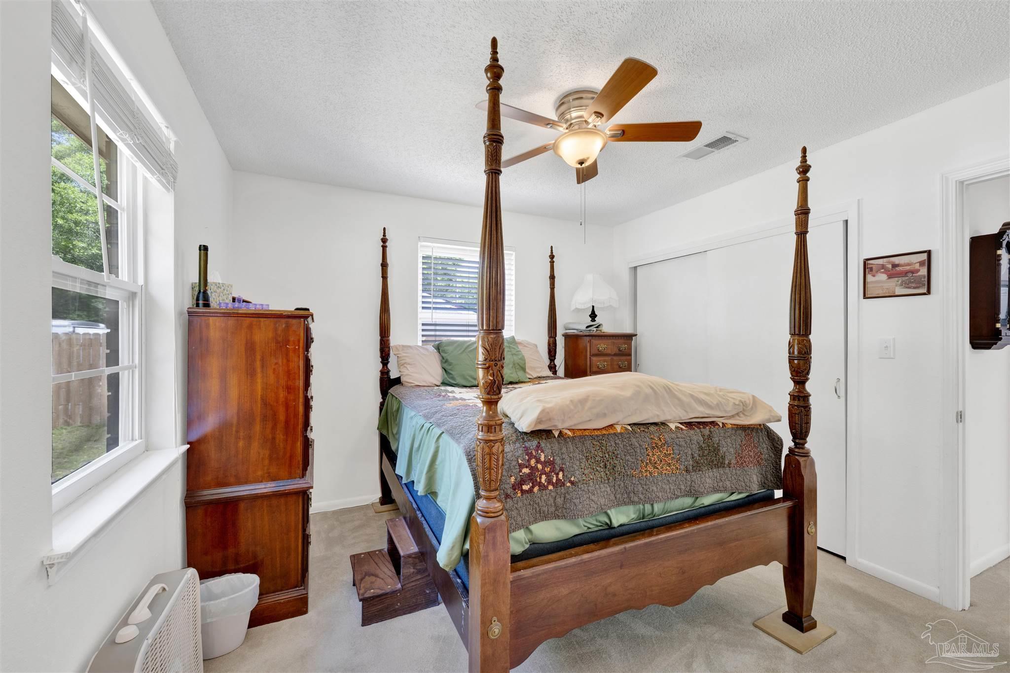 5131 Oakleaf Drive Pace, FL 32571 - Photo 9 of 23 a bedroom with a bed and wooden floor