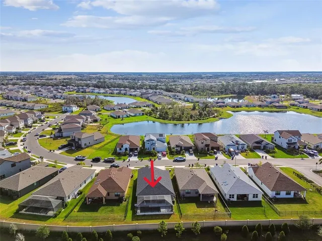 a aerial view of a house with swimming pool a yard and potted plants