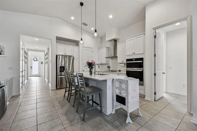 a kitchen with stainless steel appliances kitchen island granite countertop a refrigerator and a stove top oven