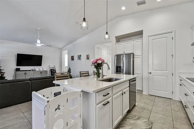 a large kitchen with kitchen island stainless steel appliances a stove a sink a dining table and chairs