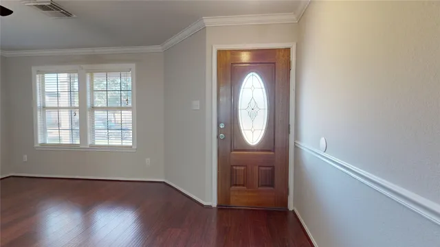 an empty room with wooden floor mirror and windows