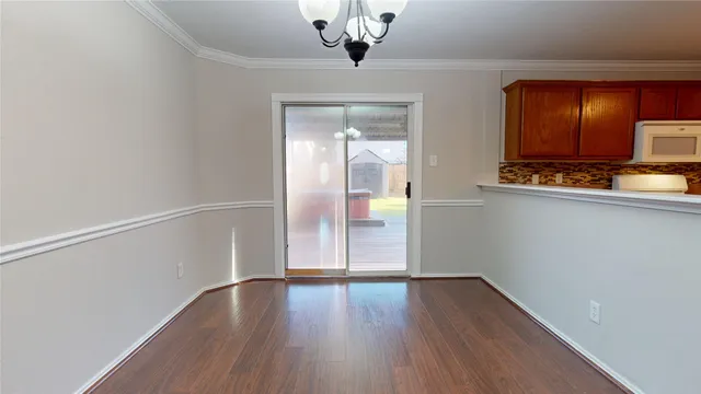 a view of a hallway with wooden floor and chandelier