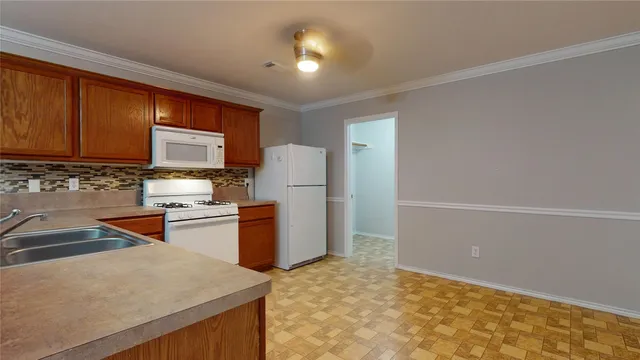 a kitchen with a refrigerator and a stove top oven