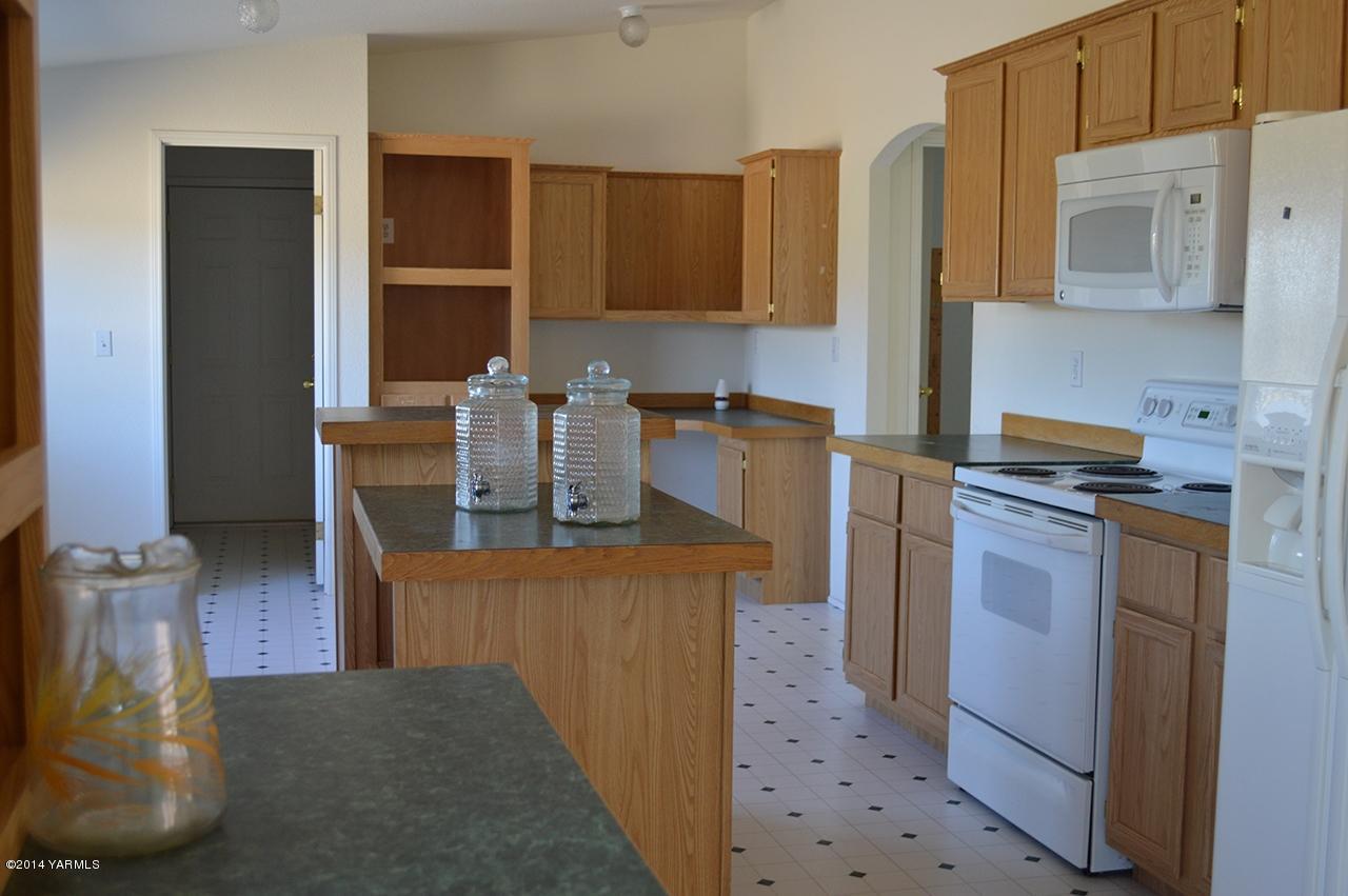 205 Mini Pines Road Yakima, WA 98903 - Photo 3 of 23 a kitchen with stainless steel appliances a stove a refrigerator a sink a counter space and cabinets