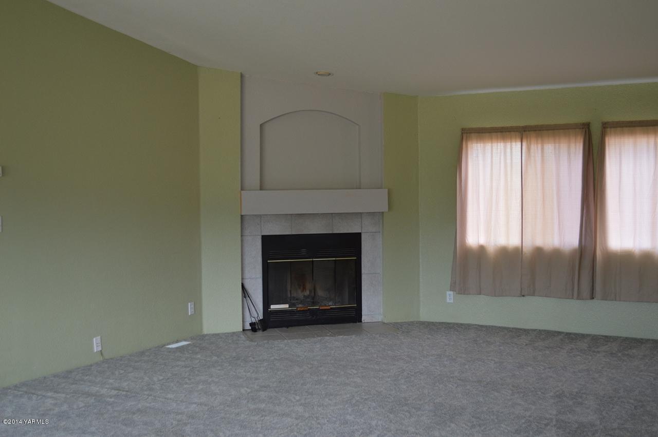 205 Mini Pines Road Yakima, WA 98903 - Photo 4 of 23 a view of an empty room with a fireplace and a window