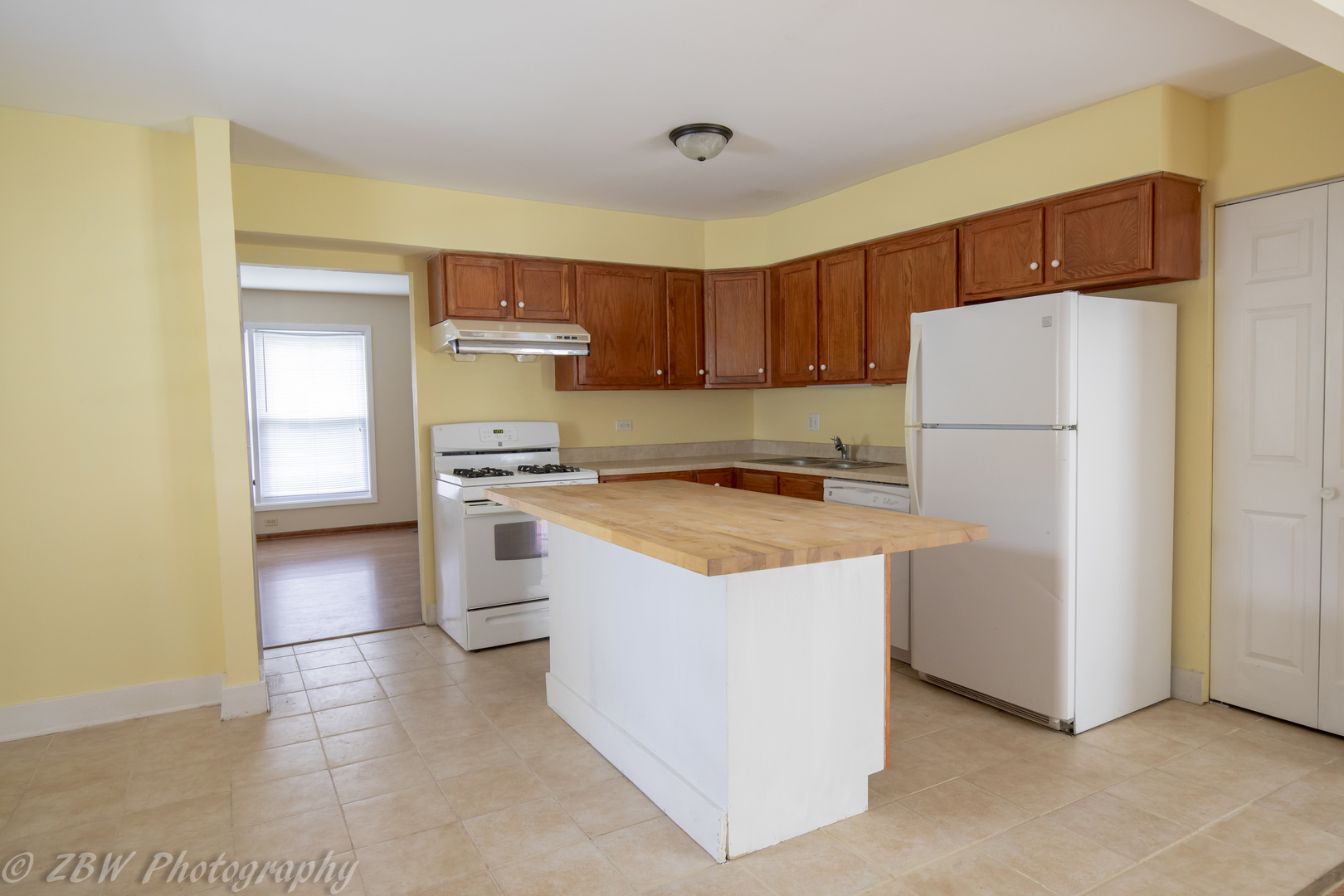 129 South Orchard Drive, Unit 1 Bolingbrook, IL 60440 - Photo 2 of 14 a kitchen with a refrigerator a stove top oven a counter space and cabinets