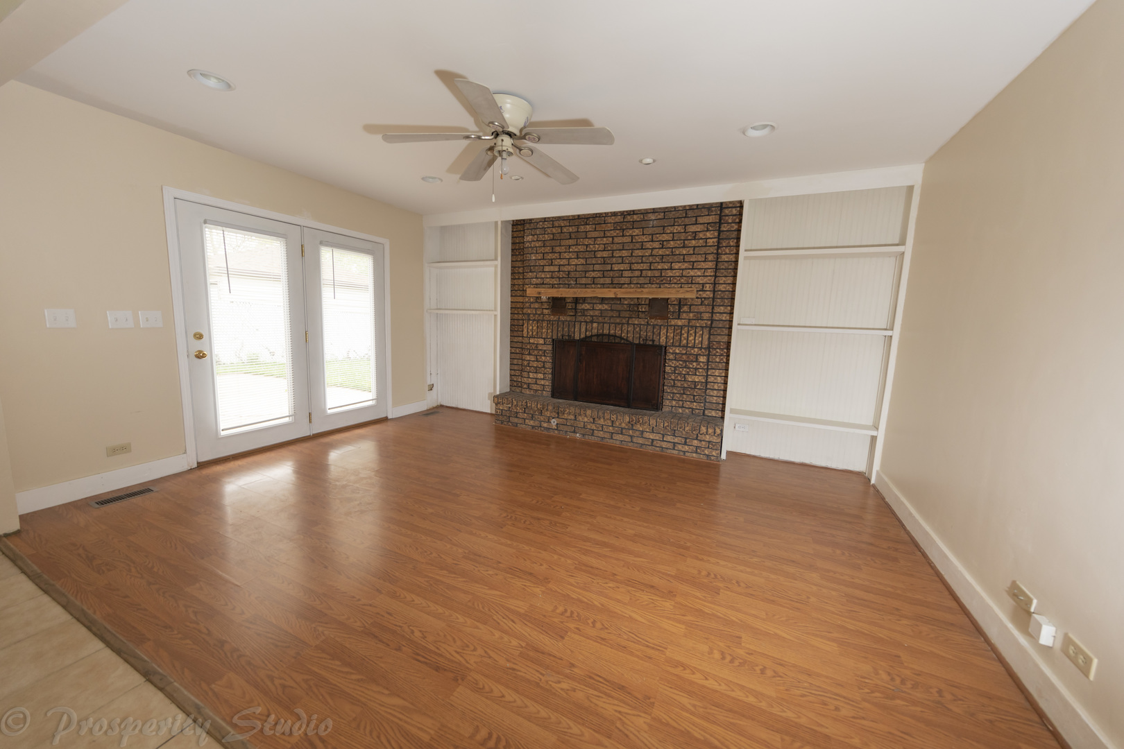 129 South Orchard Drive, Unit 1 Bolingbrook, IL 60440 - Photo 4 of 14 an empty room with wooden floor fireplace and windows