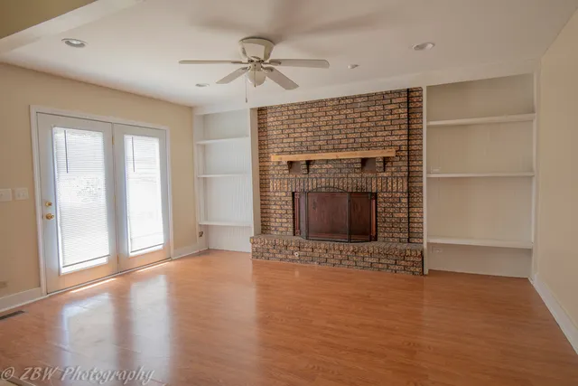 a view of an empty room with a fireplace and a window