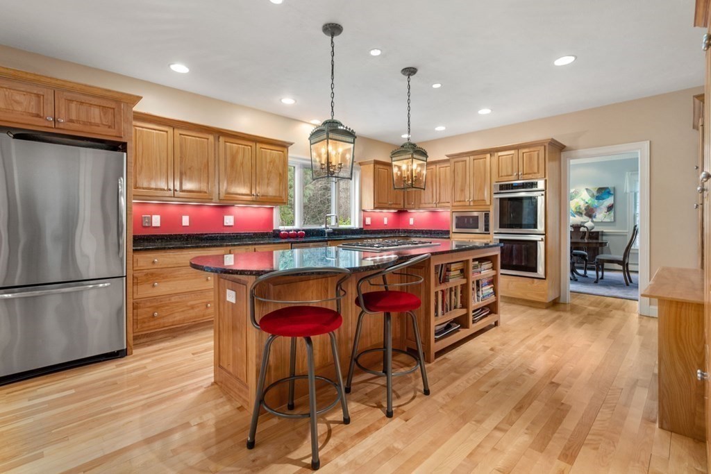 47 Claypit Hill Road Wayland, MA 01778 - Photo 8 of 21 a kitchen with stainless steel appliances granite countertop a refrigerator a sink dishwasher a oven and a dining table with wooden floor