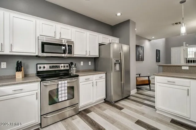 a kitchen with stainless steel appliances granite countertop a refrigerator stove a sink and a microwave