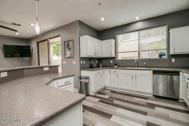 a kitchen with granite countertop a sink a counter top space appliances and cabinets