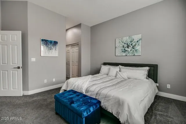 a bedroom with a bed and painting on the wall